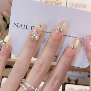 Long coffin press-on nails with nude pink base, champagne glitter French tips, and pearls