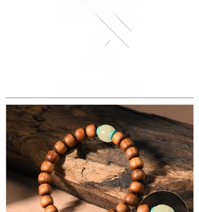 Macro detail of Thuja wood prayer beads with a jade-like green accent on textured wood