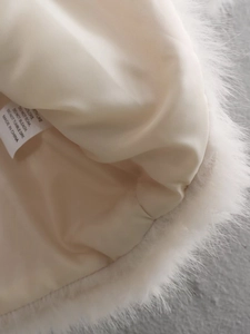 Dettaglio della fodera in raso liscio e dell'etichetta di lavaggio di un cappotto