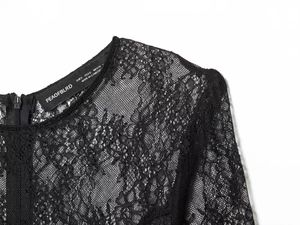 Close-up of black lace neckline with intricate floral embroidery and rear zipper detail