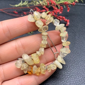 Macro detail of crescent moon hair clip with amber crystal stones and silver wire wrap