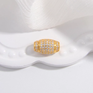 Gros plan d'une perle tonneau dorée avec zircons blancs pour bijoux artisanaux
