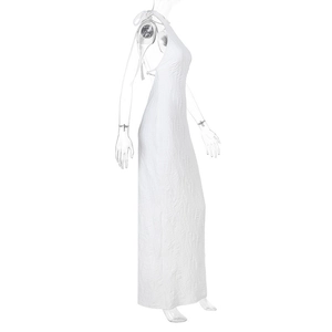 Detail of white pleated maxi dress featuring backless halter design and textured fabric