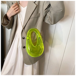 Detailed view of neon yellow transparent jelly box bag with elegant gold chain strap