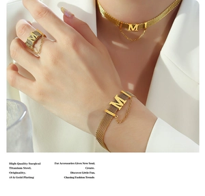 Detail of 18K gold plated titanium steel jewelry set with M pendant and mesh texture