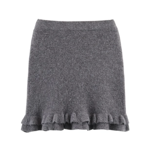Detailed view of dark grey knitted skirt featuring multi-layered ruffle hem and textures