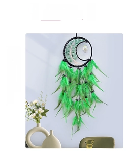 Detailed view of handmade tree of life dreamcatcher with green feathers and crystal stone