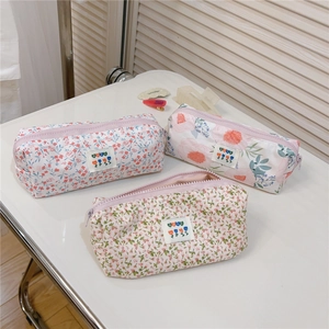 Detailed view of floral cotton pencil cases with zippers and decorative fabric labels