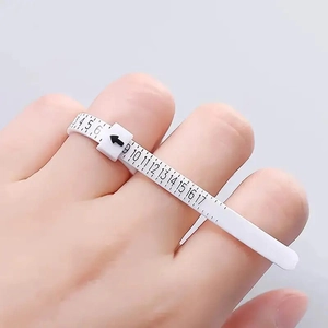 Detalle macro del medidor de anillos blanco con escalas numéricas para tallas US 3 a 17