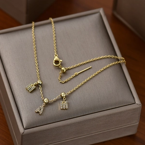 Macro shot of gold letter charms M A M with sparkling zircons on an O-chain necklace