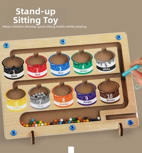 Detailed view of child using magnetic pen to sort colored beads on wooden counting board