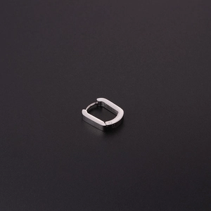 Gros plan sur une boucle d'oreille carrée en acier brossé argenté sur fond noir mat