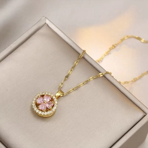 Macro view of a rotating pink flower pendant with small white gems in a luxury box