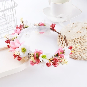 Detailed close-up of a floral wreath hair accessory with red berries and pink flowers