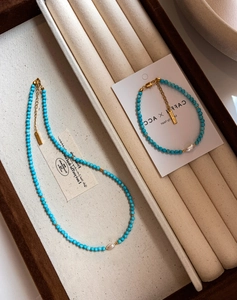 Detail of 18K gold plated necklace with turquoise beads and freshwater pearls