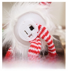 Macro view of the battery compartment and power switch on the bottom of a lighted gnome toy