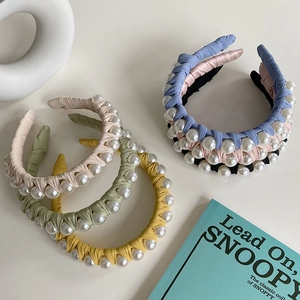 Detail showing hand-woven fabric headband with elegant faux pearl embellishments