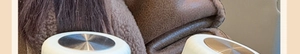 Close-up of minimalist glass cup with polished silver and gold lids on a premium fabric