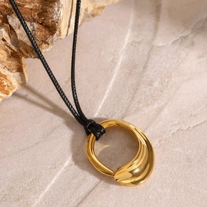 Minimalist gold irregular hollow pendant necklace with black woven cord on stone