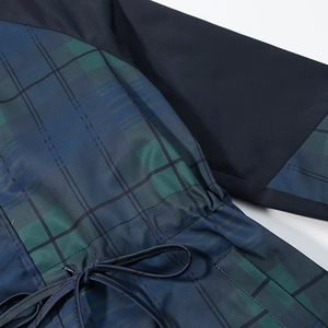 Détail de la taille à cordon et du patchwork à carreaux verts sur la veste