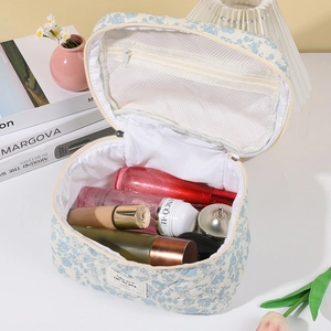 Quilted floral cosmetic bag in light blue cotton fabric with handle and zipper closure