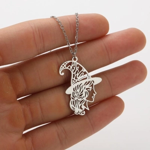 Detailed macro of silver hollow witch silhouette pendant on stainless steel necklace