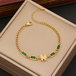 Golden butterfly necklace with emerald zircon stones displayed in a beige jewelry gift box