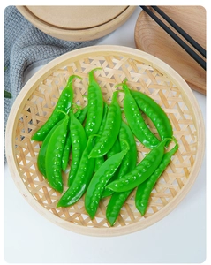 Realistic artificial green snow peas in a woven basket for food photography props