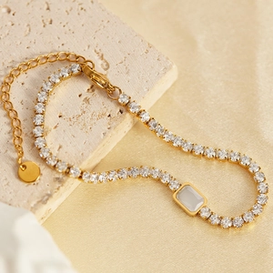 Detail of gold plated tennis bracelet featuring white zircons and rectangular center stone