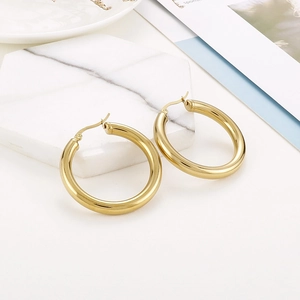 Detailed close-up of 18K gold-plated chunky hoop earrings with a mirror-polished finish