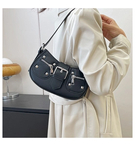 Detail view of black matte underarm bag featuring silver rivets and punk style buckles