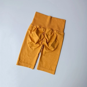 Macro view of ginger yellow high-waisted seamless scrunch butt yoga shorts fabric