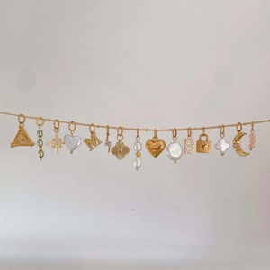 Detailed view of gold DIY necklace featuring heart, star, moon, and pearl charms