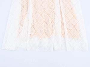 Detail des weißen Spitzenkleids mit Rautennetz-Muster und hautfarbenem Futter