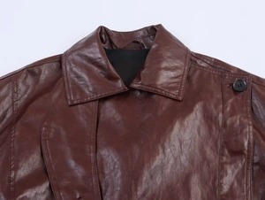Detail of a deep brown faux leather jacket featuring a classic lapel and button accent