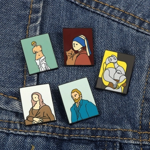 Artistic enamel pins featuring famous paintings set against a dark blue denim background