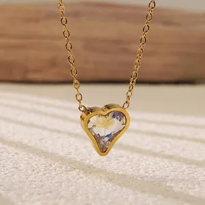 Macro detail of a gold heart pendant necklace featuring a sparkling clear zircon crystal
