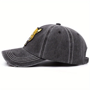 Detailed close-up of leopard embroidery and distressed brim on washed denim baseball cap