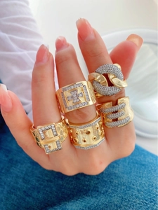 Detailed view of five gold-plated rings with cubic zirconia on a model's hand