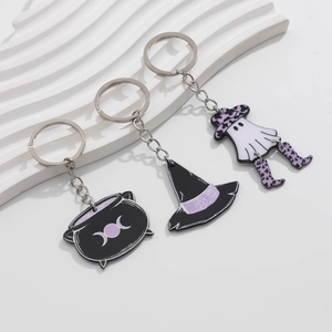 Detail of Halloween keychain set with witch hat, cauldron and ghost on a white stand
