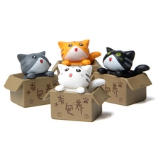 Detail of four colorful toy cats sitting in small cardboard boxes with cute expressions