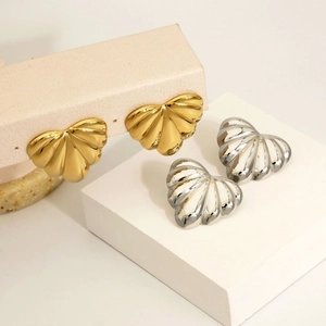 Elegant gold and silver heart-shaped fan-textured earrings on a display stand