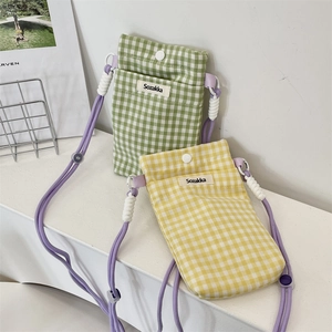 Vue détaillée de pochettes de téléphone en tissu à carreaux vert et jaune avec cordes