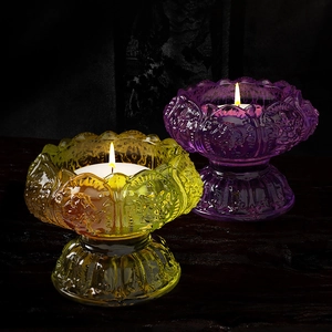 Detailed view of lotus flower glass candle holders in vibrant yellow and deep purple colors