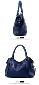 Close-up of a large capacity dark blue soft leather shoulder bag with gold hardware