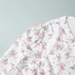 Detail of floral puff sleeve and pleated shoulder on white chiffon spring dress