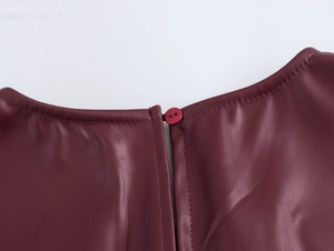 Detailed macro shot of deep red PU leather back neckline with button closure and stitching