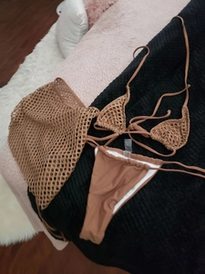 Three-piece brown bikini set featuring a crochet mesh cover-up skirt and halter top