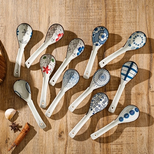 Set of 12 Japanese style ceramic spoons with floral patterns on rustic wooden table