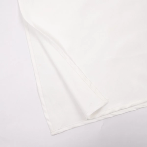 Détail du haut fendu latéral d'une robe d'été blanche dos nu à fines bretelles